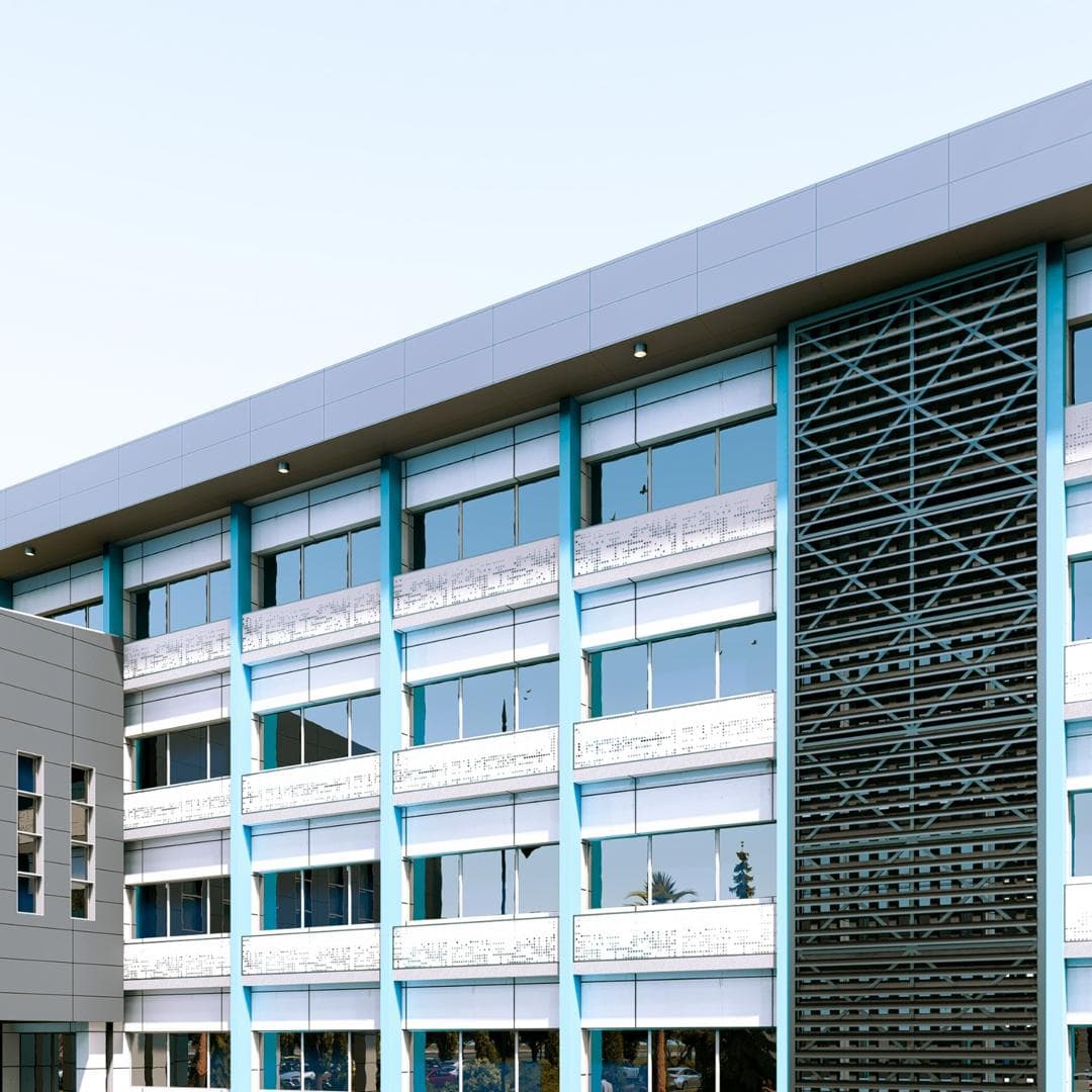 Multi-storey building with white and grey cladding and a patterned screen